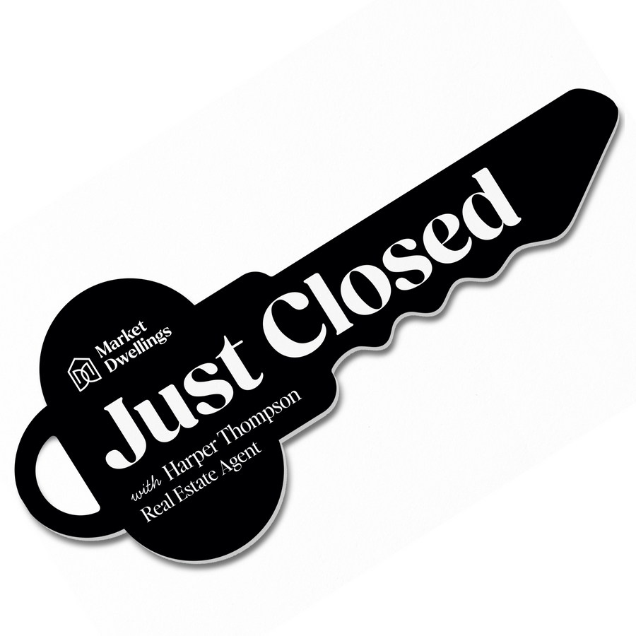 Black key-shaped sign with 'Just Closed' text and real estate agent information on a white background